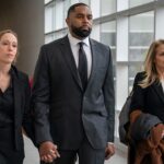 Sherrone Moore and wife hold hands in Michigan court